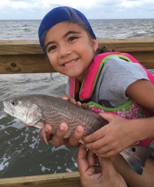 Seven-year-old Abryanna Rivera of Timberwood Park caught this 16-inch red on live shrimp while fishing from a pier on Aransas Bay.