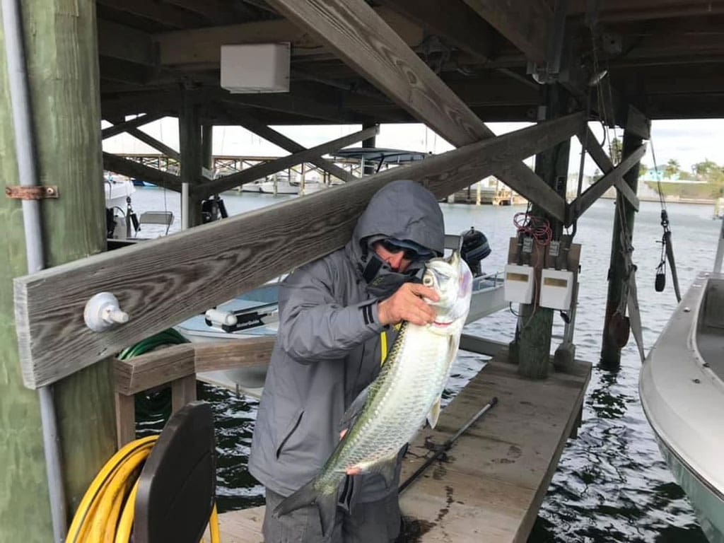 Dean Thomas of Slow-Ride Guide Services with a dead tarpon he found after the freeze in the Aransas Pass area.