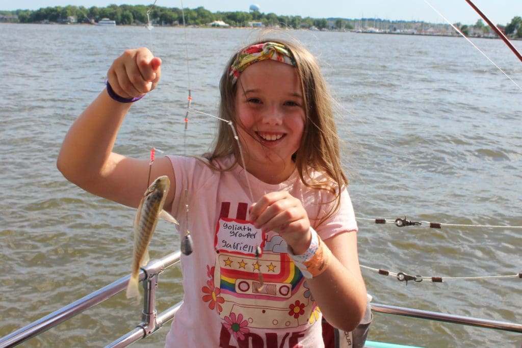 a kid holds up the catch