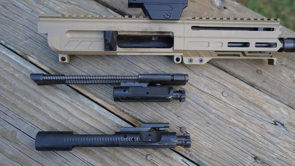 The Dissent operates with a hybrid AR15 bolt (top) assembly utilizing the Radial Delayed Blowback system. A standard bolt (bottom) is for comparison.
